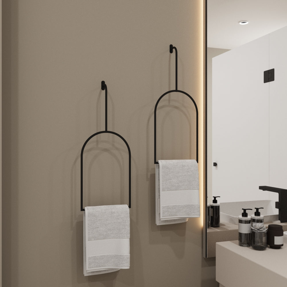 Minimalist black arched towel rings mounted on a neutral beige bathroom wall, holding white towels, adding an elegant and modern touch to the bathroom decor.