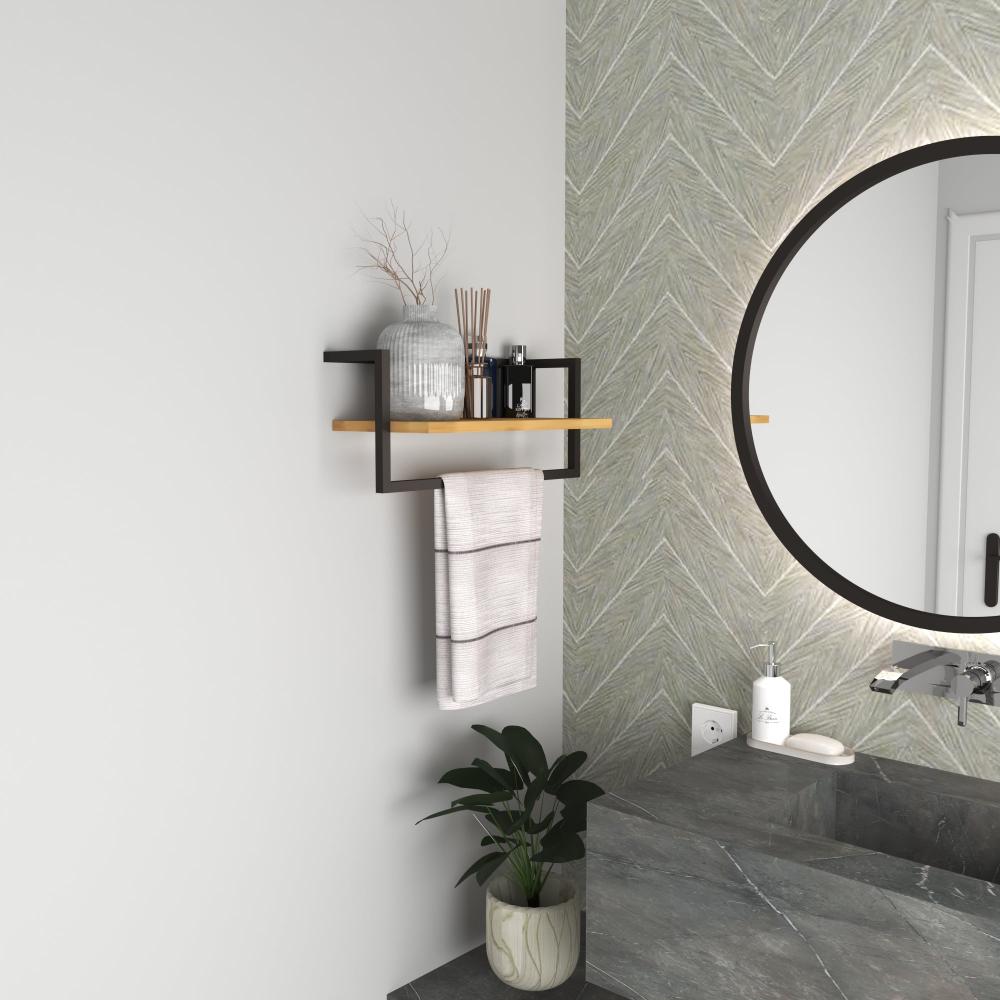 A modern bathroom shelf with a matte black metal frame and a wooden plank, holding decorative items like a vase and reed diffusers, with a towel hanging below