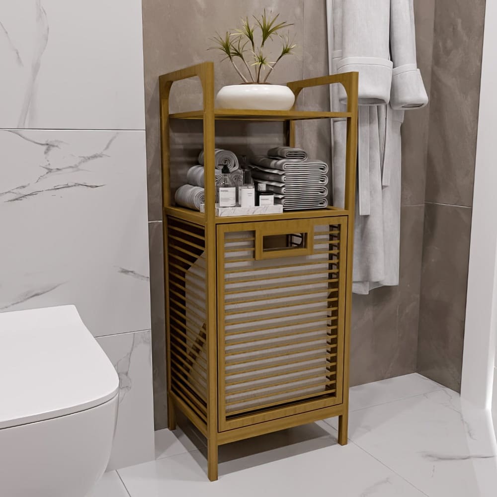 A compact bamboo bathroom storage cabinet with a tilt-out laundry basket, two open shelves holding neatly folded towels, and a decorative white vase on top