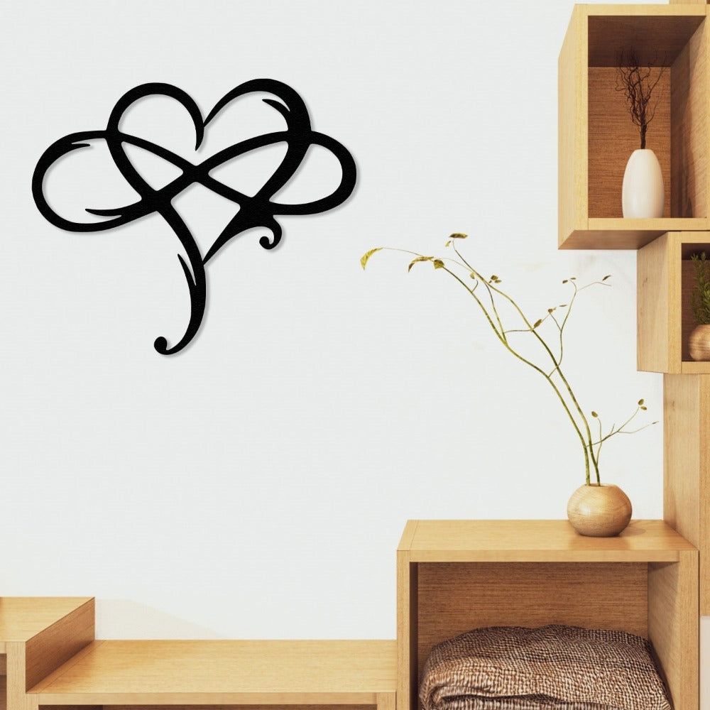 Black intertwined heart-shaped metal wall art displayed in a cozy living room with light wooden shelves and minimalist decor.