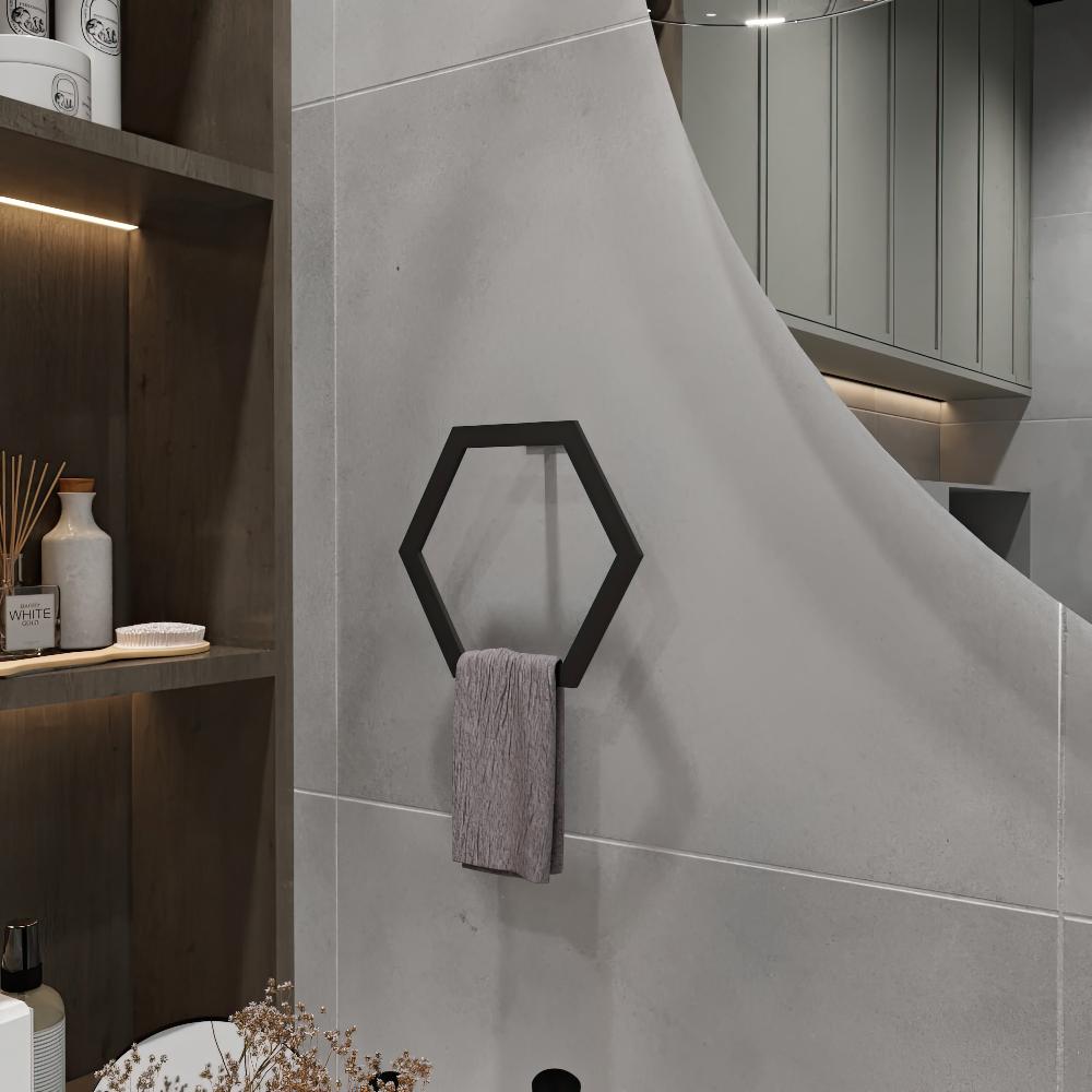 Black hexagon-shaped towel ring mounted on a gray bathroom wall, holding a gray towel, with wooden shelves and modern lighting in the background.