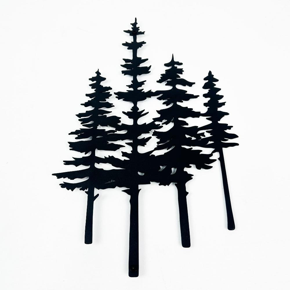 Close-up of black metal pine tree wall art on a plain white background, showcasing intricate details of tree silhouettes.