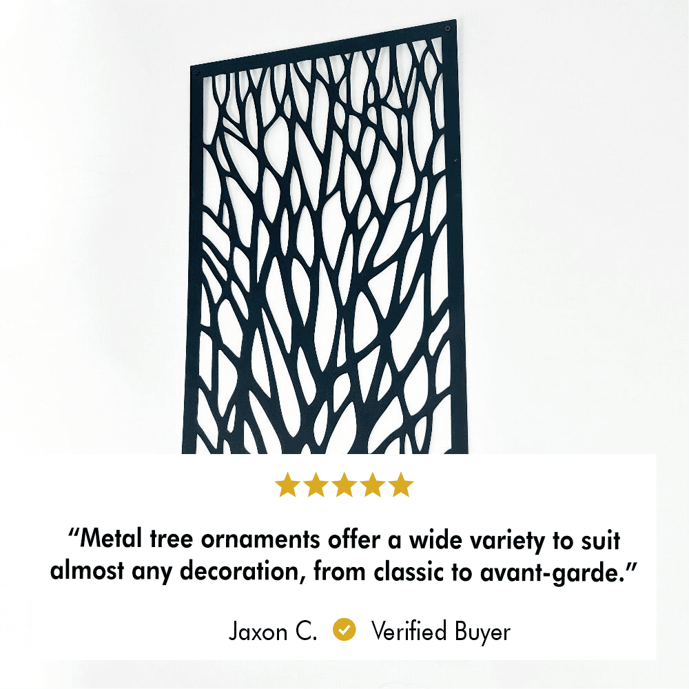 Close-up view of a black metal tree wall art piece with intricate branch designs mounted on a white wall. Below, a 5-star review by Jaxon C. reads, "Metal tree ornaments offer a wide variety to suit almost any decoration, from classic to avant-garde." The review highlights the product's versatility and appeal for diverse decor styles.