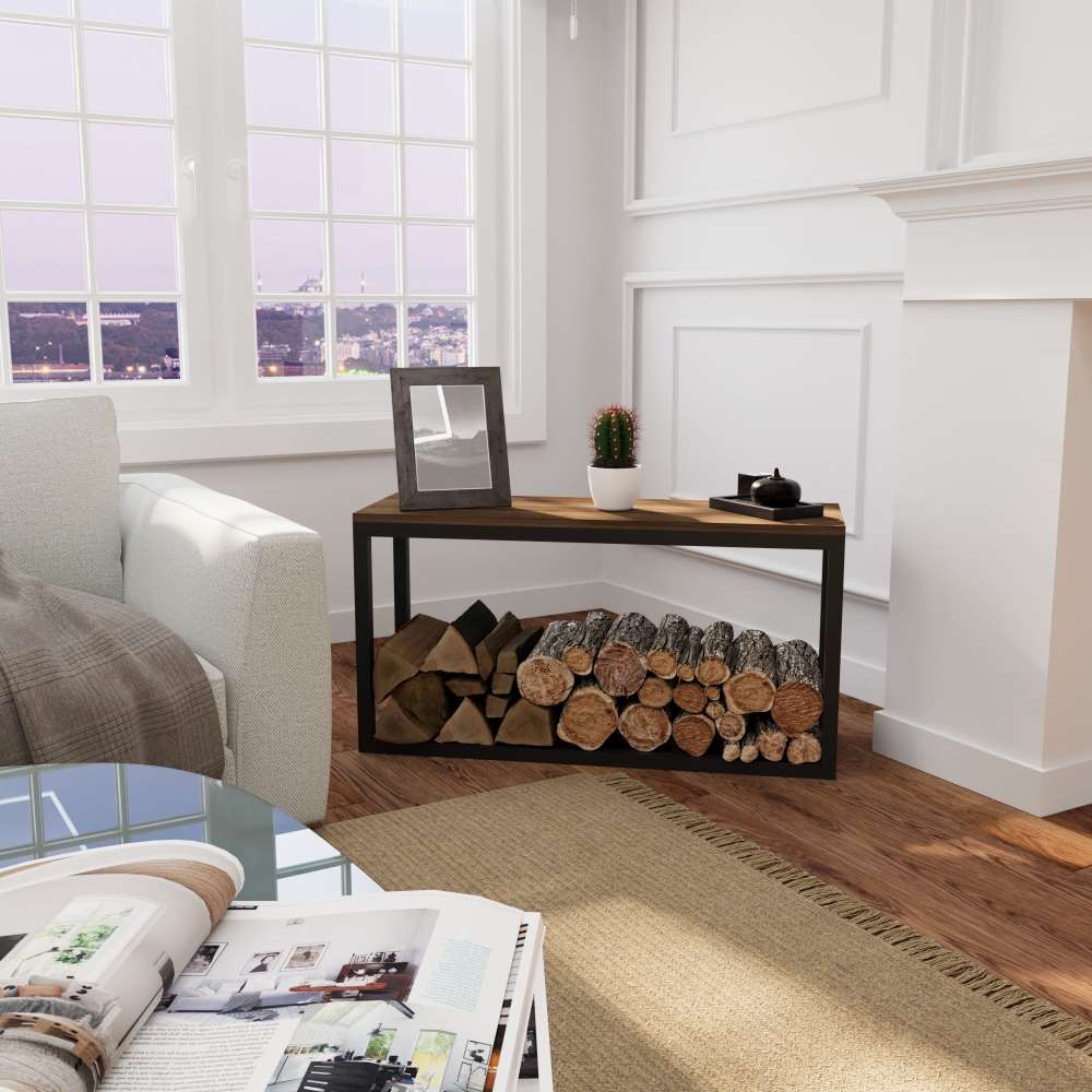 A black metal wood rack with a wooden top placed in a cozy living room, storing firewood neatly below, complemented by a small cactus and frame on top.