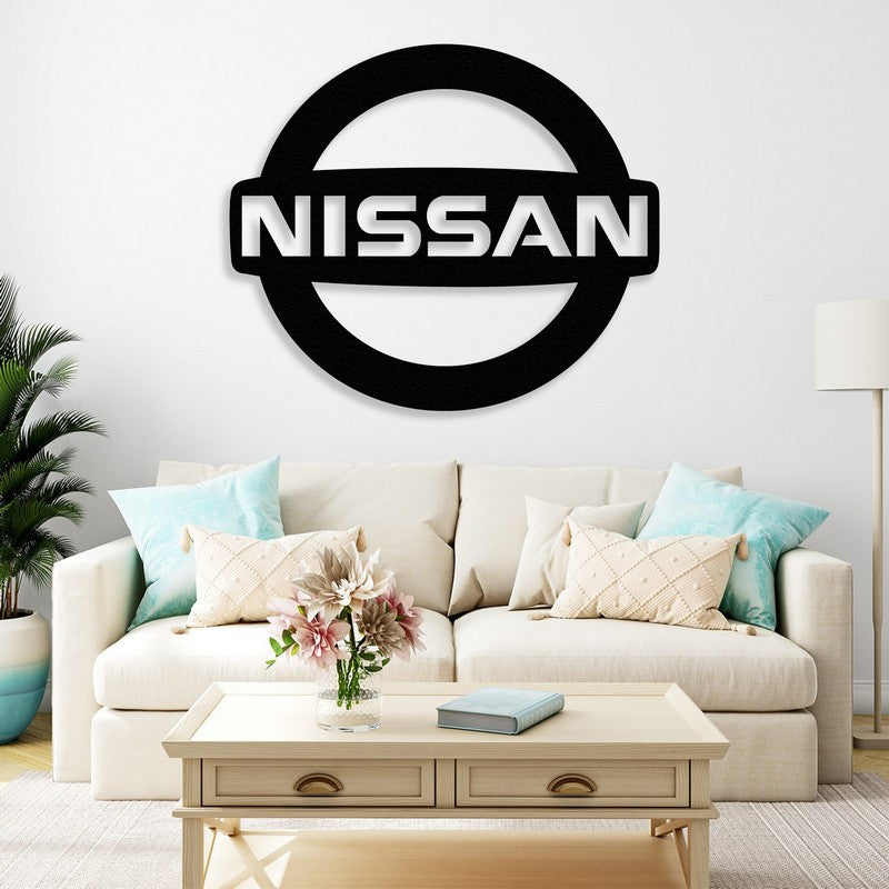 Black Nissan-inspired metal wall art mounted above a cozy cream-colored sofa with decorative pillows in a modern living room setup.