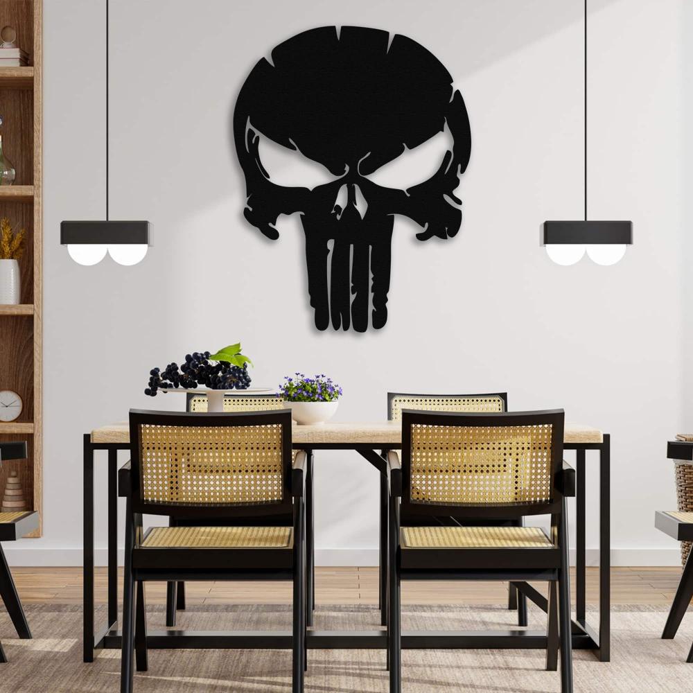 A black Punisher skull metal wall art mounted on a white dining room wall, complementing a modern dining setup with a wooden table and rattan chairs.