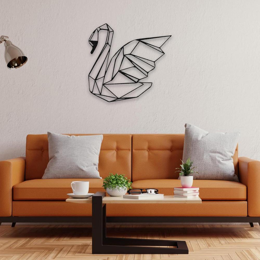  A geometric black swan metal wall art above an orange couch with gray cushions, complemented by a small plant and books on a wooden coffee table.