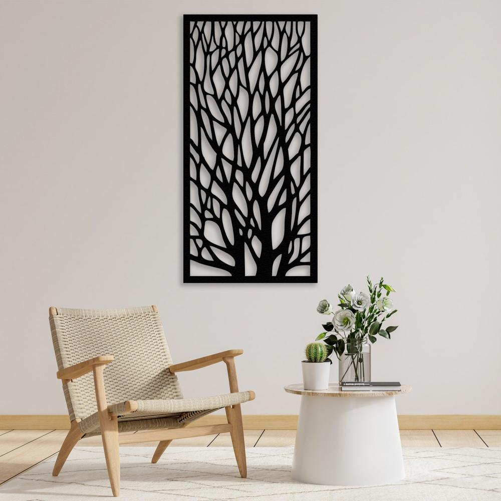 Modern living room setup featuring a black tree silhouette metal wall art mounted on a light wall. A woven beige armchair and a white round side table adorned with flowers and a small cactus complement the minimalist decor.