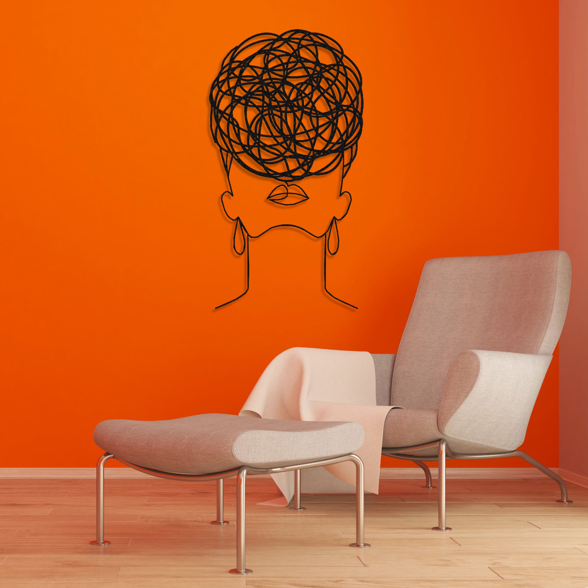 Minimalist black metal wall art of a woman with circular pattern hair, mounted on a vibrant orange wall above a modern lounge chair.