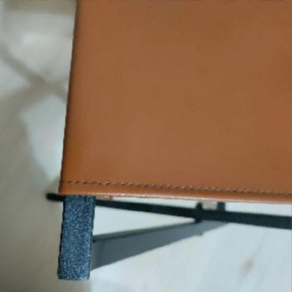 A close-up of the high-quality brown leather material of the foldable metal rack showcasing the fine texture and craftsmanship