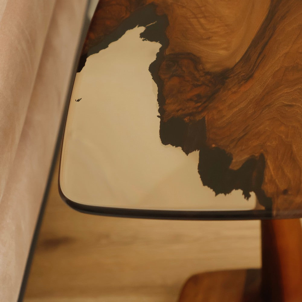 A close-up of the black resin and natural wood grain patterns on a modern wooden side table, highlighting the intricate resin design.