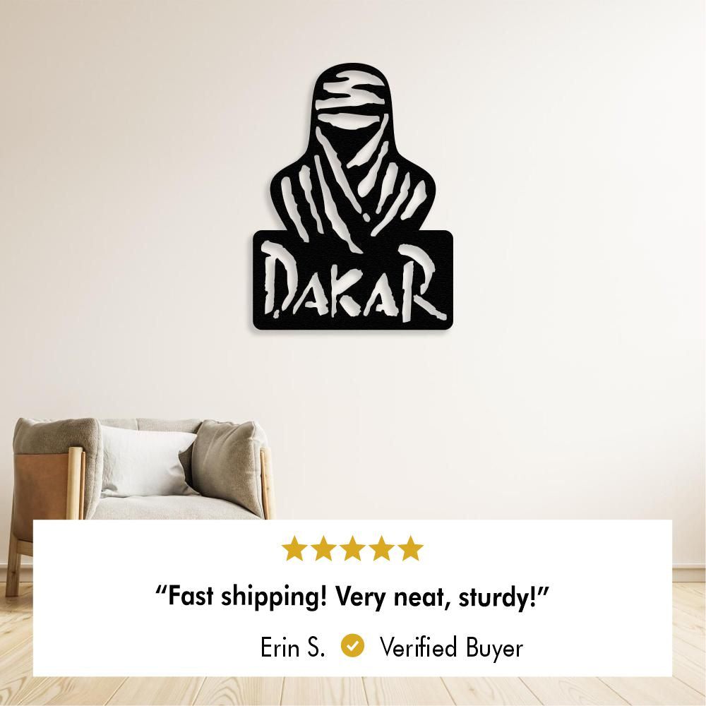 Black metal wall art depicting a veiled figure and the word "Dakar" on a pale wall above an armchair, with a five star review below stating:  “Fast shipping! Very neat, sturdy!”  by Erin S. Verified Buyer.