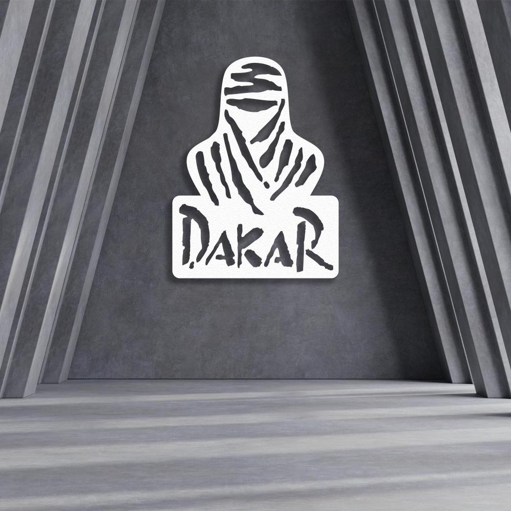 White Dakar Rally metal wall art featuring a desert nomad silhouette with bold "Dakar" lettering, displayed on a textured gray wall in a modern geometric space.