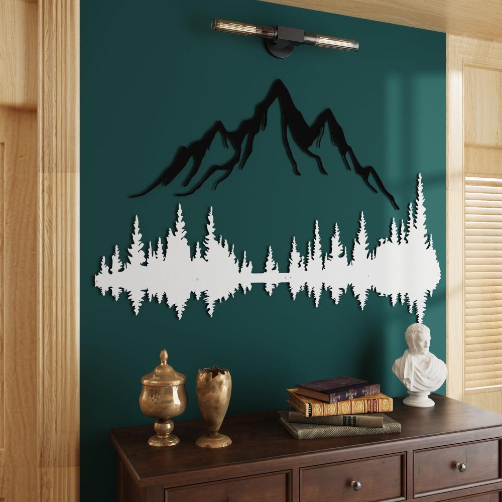 Dual-tone mountain and forest metal wall art featuring black mountains and white forest silhouettes mounted on a green wall, paired with a dark wooden console table adorned with antique gold decor items, books, and a classical white bust.