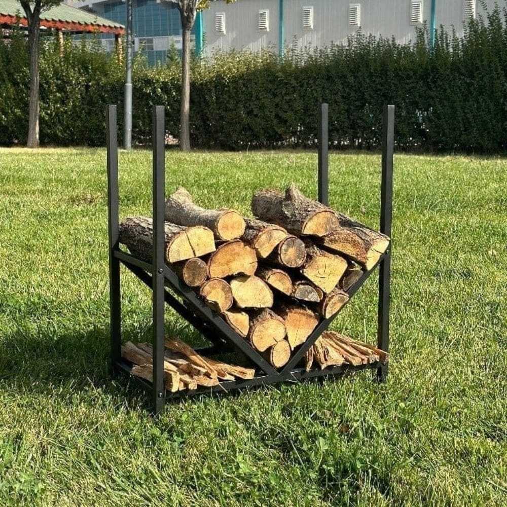 A modern black metal firewood rack with firewood and kindling arranged, featuring a geometric V-shape structure, placed in an outdoor grassy garden area