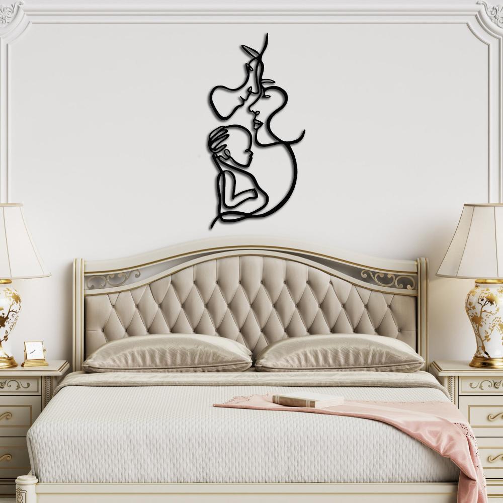 Decorative black metal family line art piece mounted above a luxurious classic bed with gold-accented furniture.