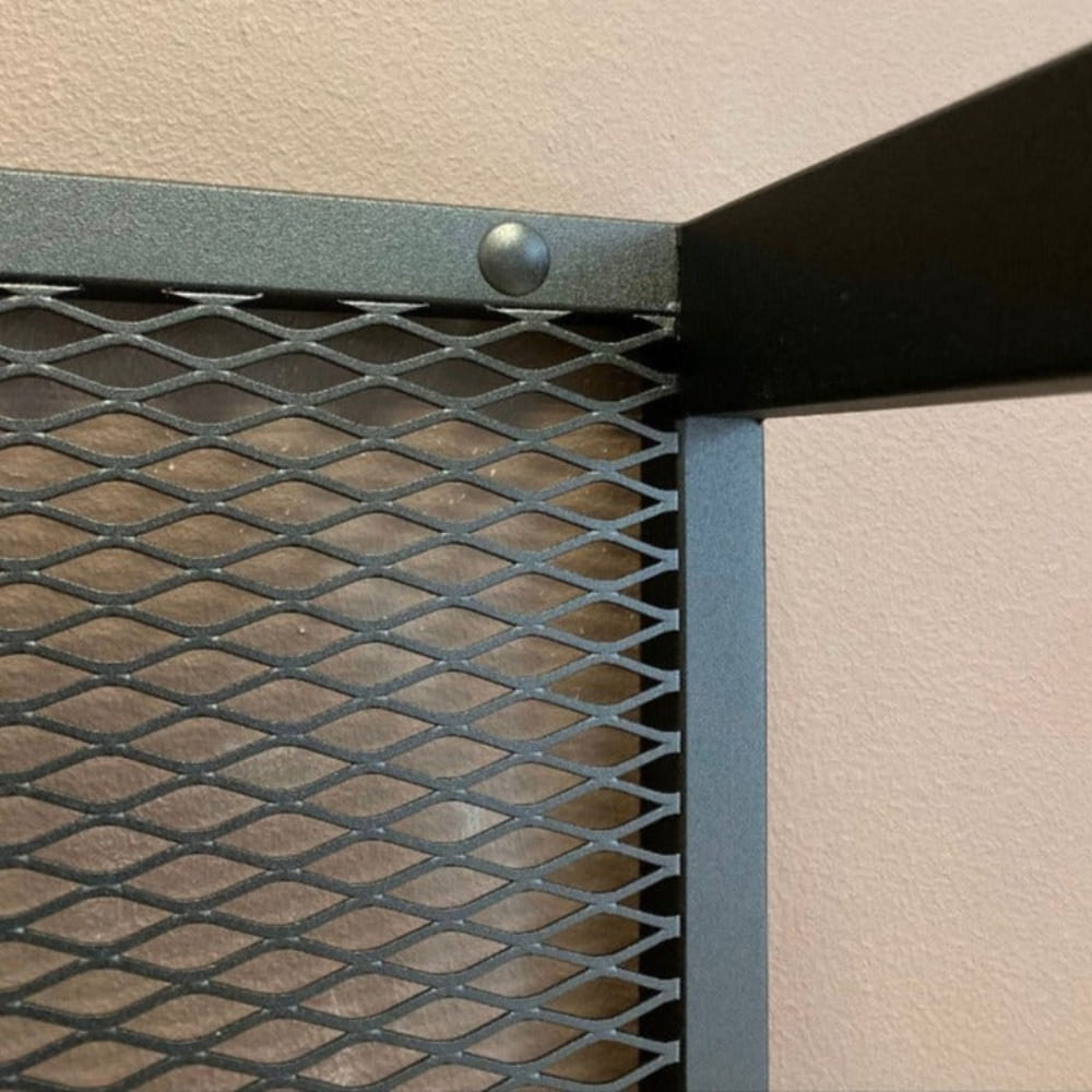 Close-up of the top corner of a wall-mounted firewood holder showing its sturdy black mesh and metal construction details.