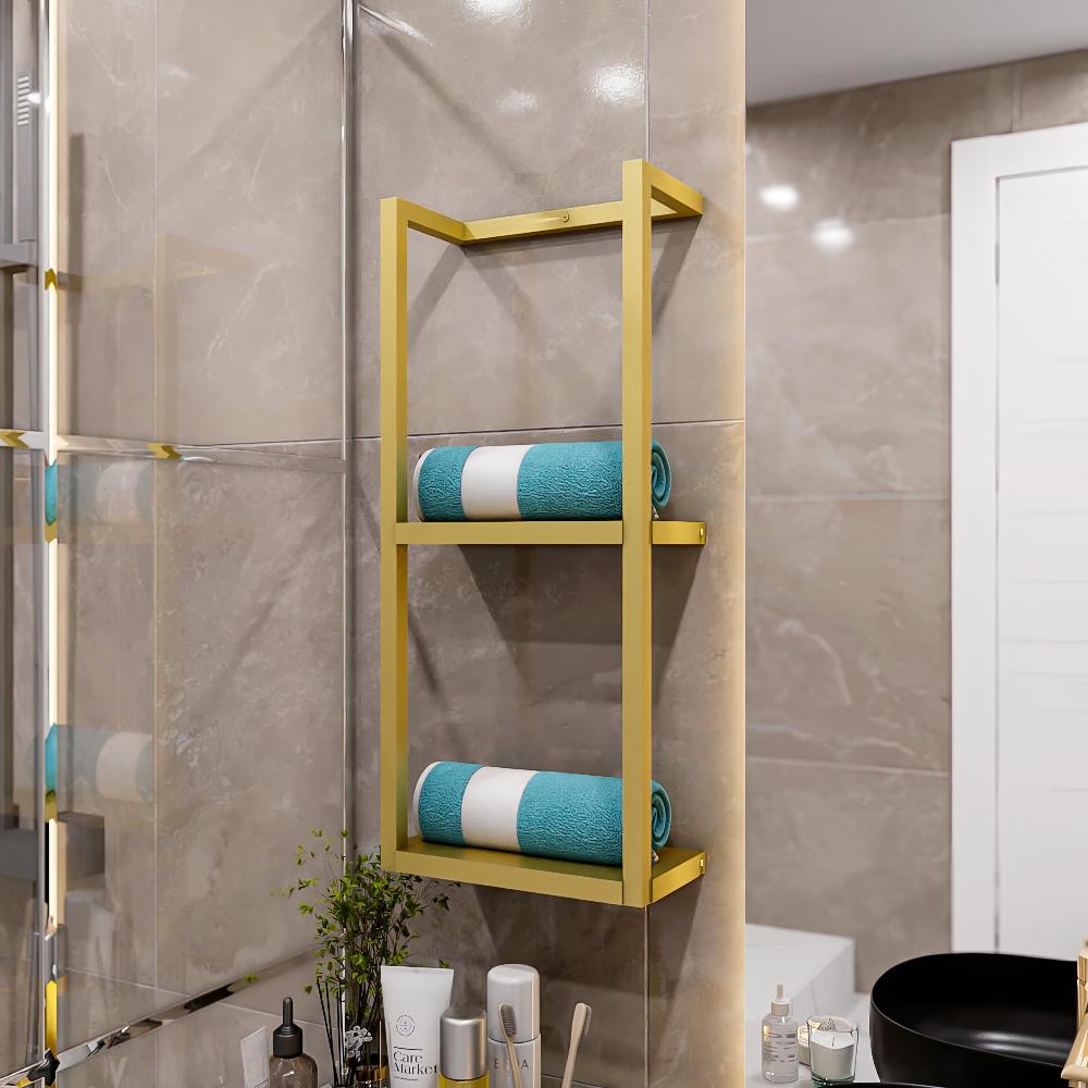 Gold metal floating shelf for bathroom with two tiers, each holding a rolled teal towel with a white stripe. The shelf is mounted on a beige tiled wall, complementing a modern bathroom setup with a variety of toiletries and a plant on the counter below.