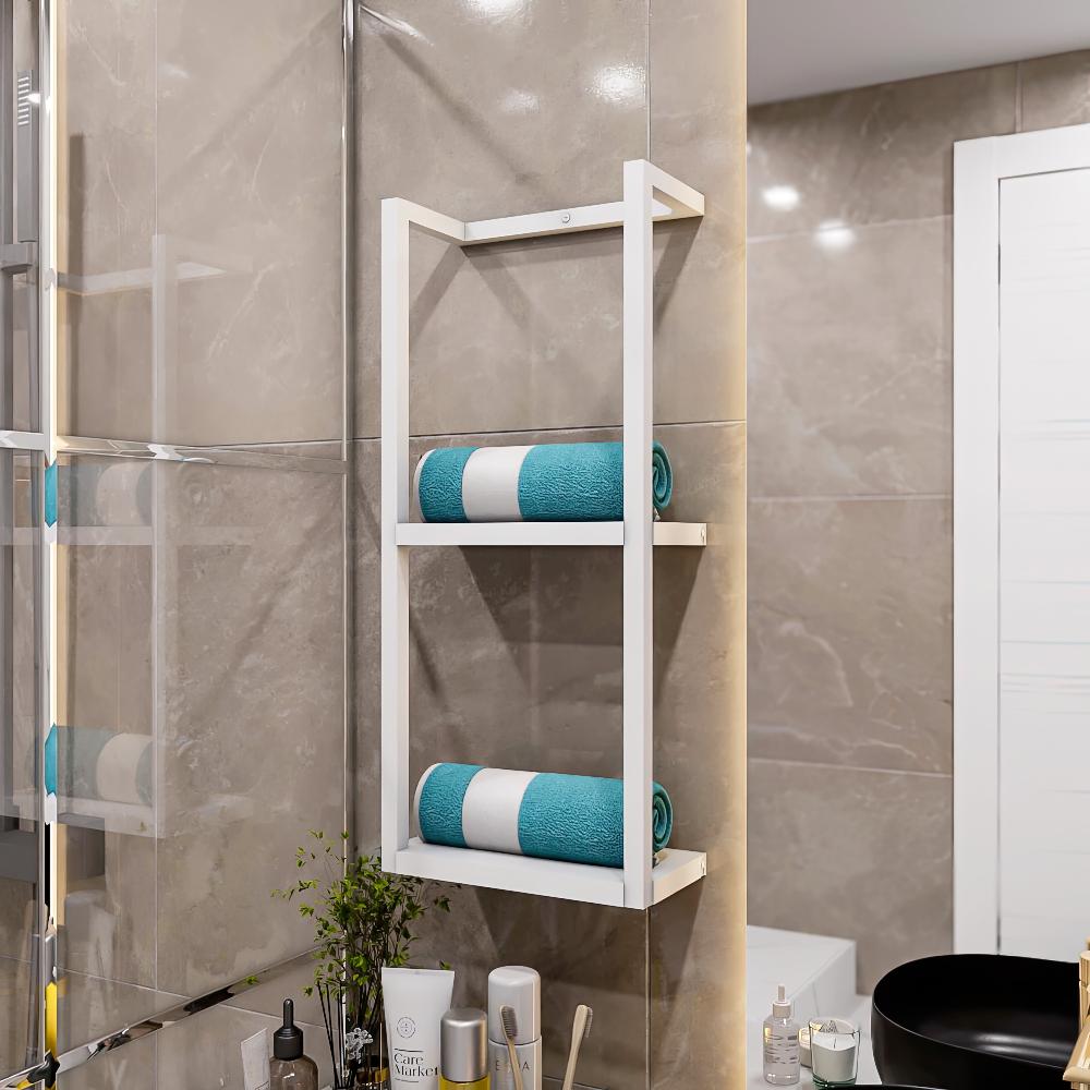 White metal floating shelf for bathroom with two tiers, each holding neatly rolled teal towels. The shelf is mounted on a beige tiled wall above a countertop with various bathroom essentials.