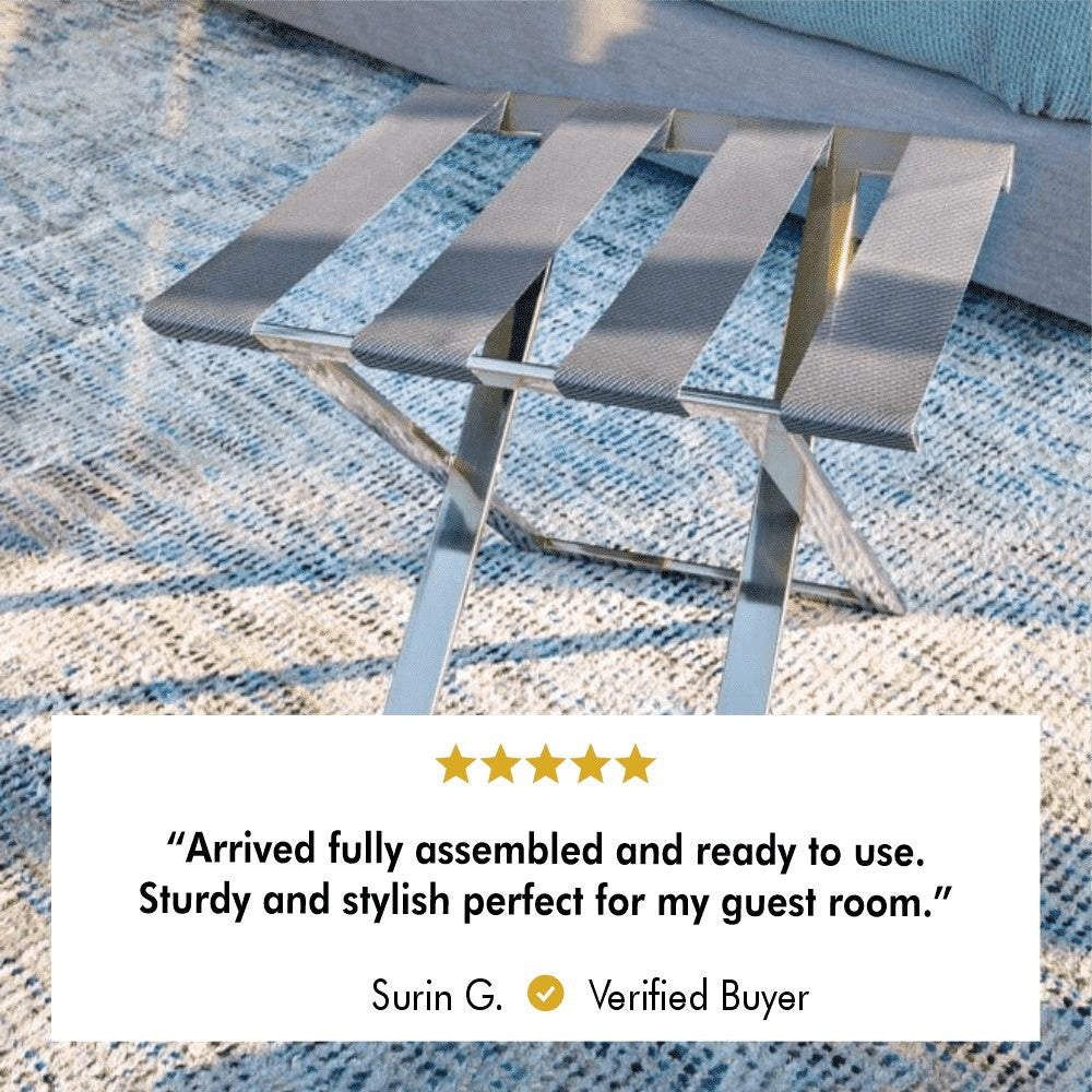 A foldable metal luggage rack with a customer review reading "Arrived fully assembled and ready to use. Sturdy and stylish perfect for my guest room" by Surin G., displayed with a five-star rating.