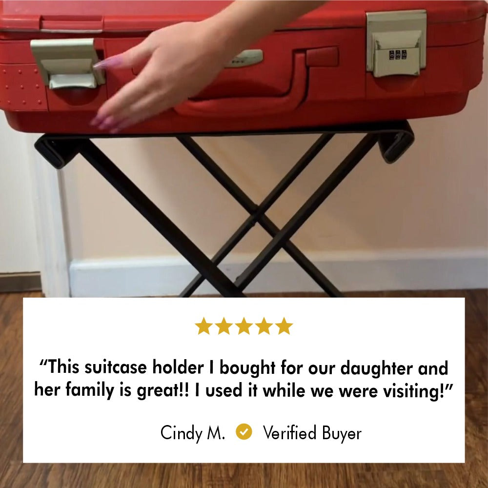 Foldable metal luggage rack holding a red suitcase, accompanied by a five-star review from Cindy M., a verified buyer, stating, "This suitcase holder I bought for our daughter and her family is great!! I used it while we were visiting!"