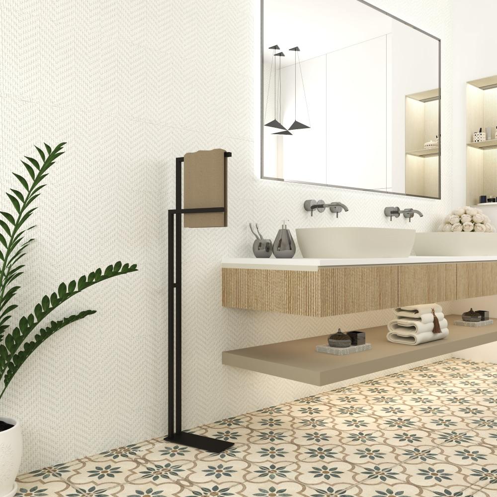 A sleek black free-standing towel holder placed in a modern bathroom with floral tile flooring, holding a beige towel