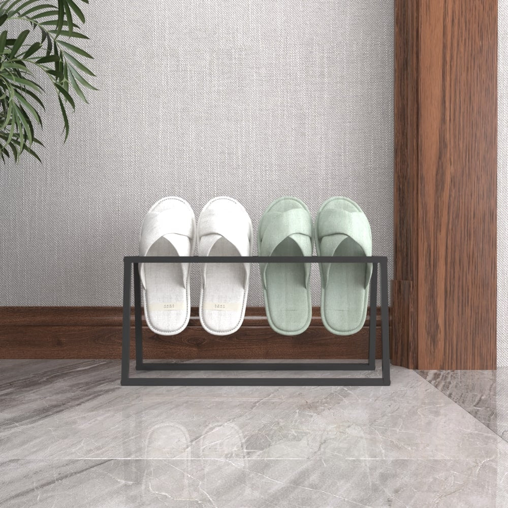 Front view of a black metal slipper holder with white and mint-green slippers neatly organized, set against a wooden wall and marble flooring