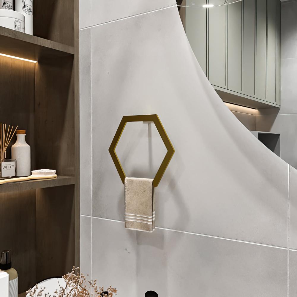  Gold hexagon-shaped towel ring mounted on a gray bathroom wall, holding a beige towel, adding a touch of luxury to the decor.