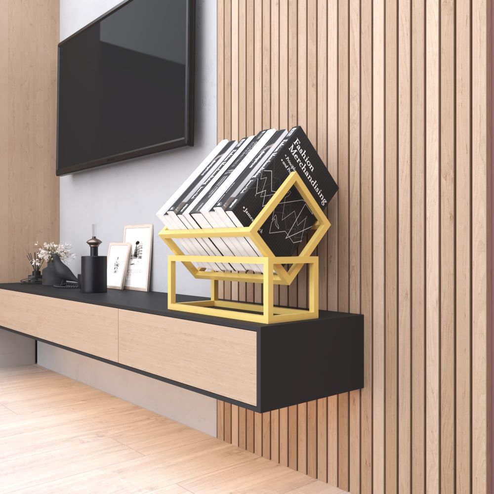 A gold metal book rack on a modern black console table, holding books, blending with a sleek wooden wall panel background