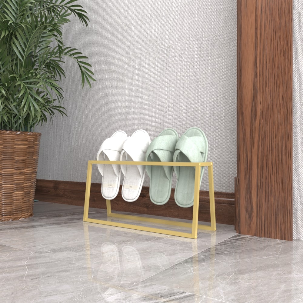 A gold metal slipper holder holding white and mint-green slippers, providing a modern touch, positioned next to a wooden wall and marble floor