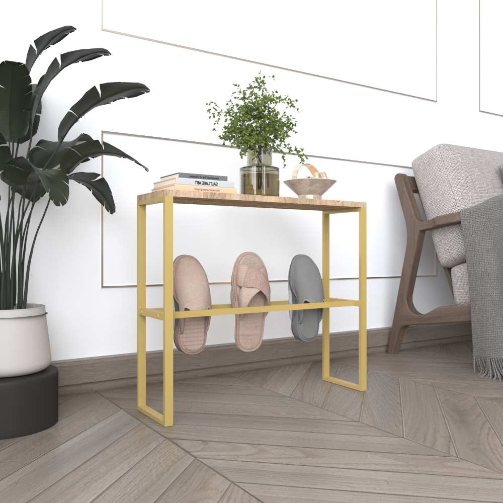 A gold metal slipper rack with a wooden top, accessorized with decorative plants and books, shown in a cozy, well-decorated living room with warm tones.