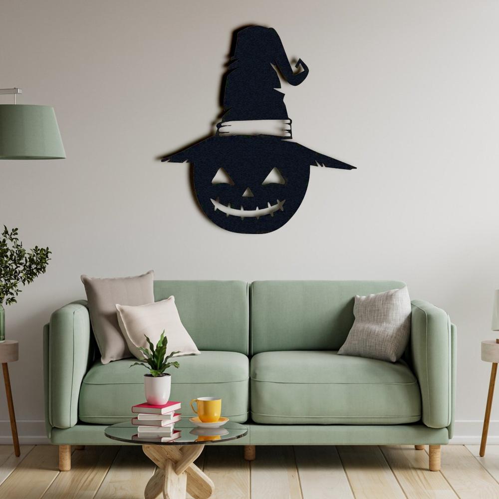 Halloween-themed black metal wall art of a jack-o'-lantern with a witch's hat, displayed on a wall behind a light green sofa adorned with pastel cushions.