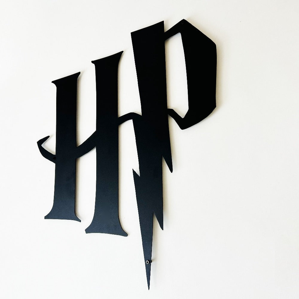 Black Harry Potter "HP" metal logo with a lightning bolt design mounted on a plain white wall, captured at an angled perspective highlighting its dimensional details.