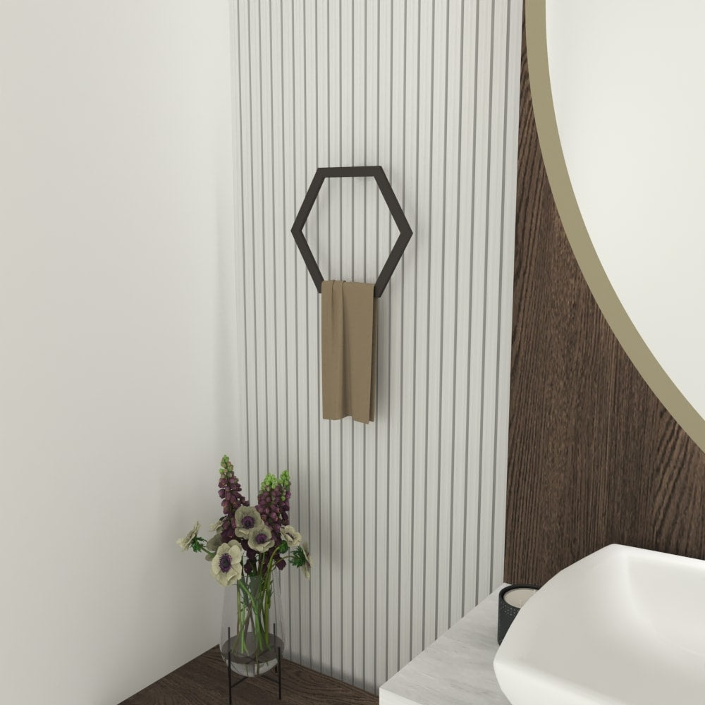 Black hexagon-shaped towel ring mounted on a white striped wall with a beige towel, next to a wooden vanity and a round mirror in a modern bathroom.