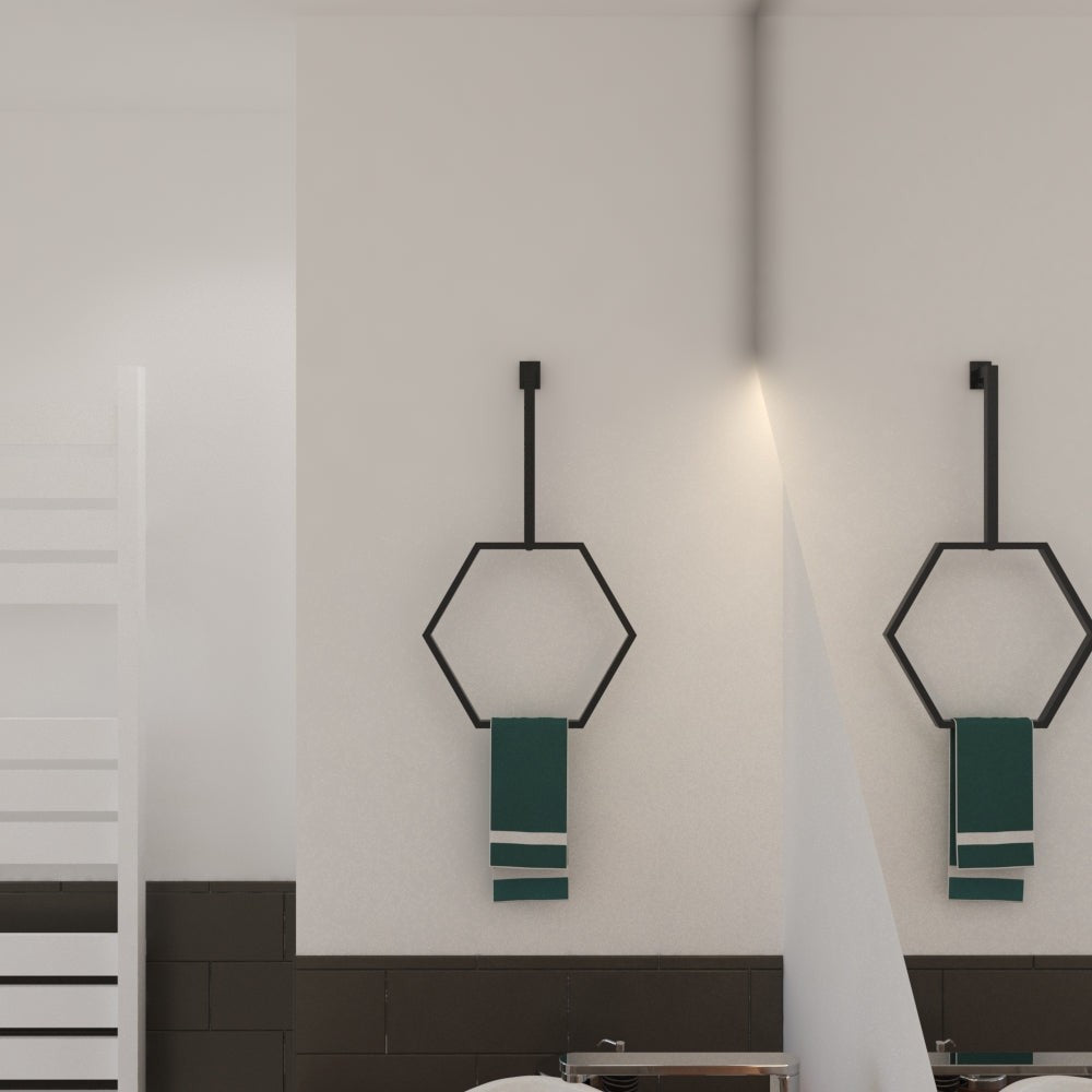  A pair of black hexagonal towel rings mounted side by side on a minimalist bathroom wall, each holding green towels, creating a balanced and modern aesthetic.