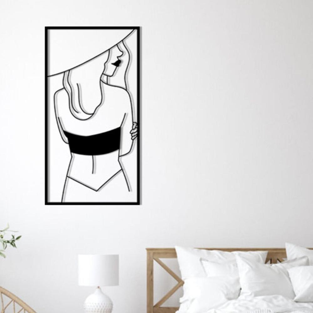 Minimalist bedroom with a white bed and a framed metal wall art of a woman in a hat, creating a serene and stylish decor.