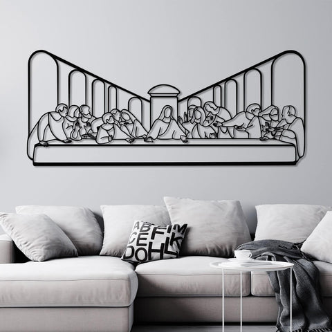 Black metal wall art depicting "The Last Supper" scene, mounted on a light gray wall above a modern gray sofa with white and patterned cushions.