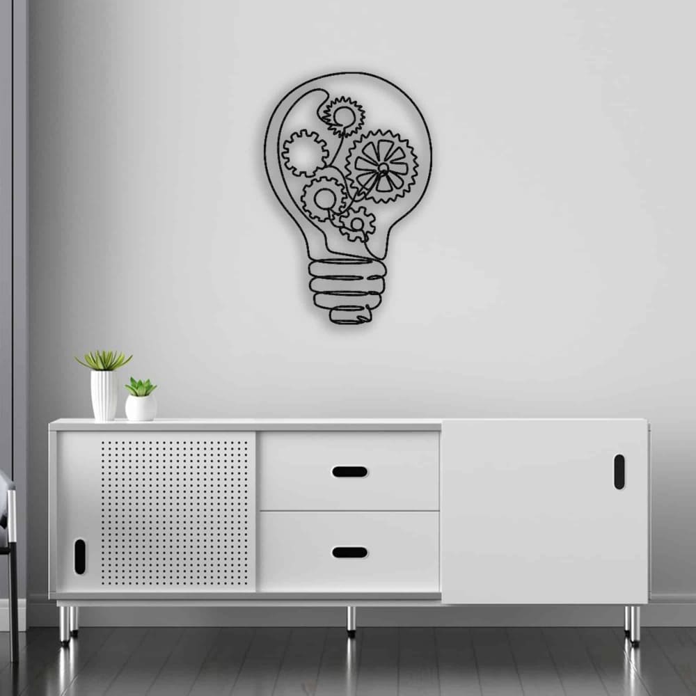 Light bulb-shaped metal wall art with intricate gear designs, mounted above a modern white cabinet with sliding doors, complemented by small green plants.