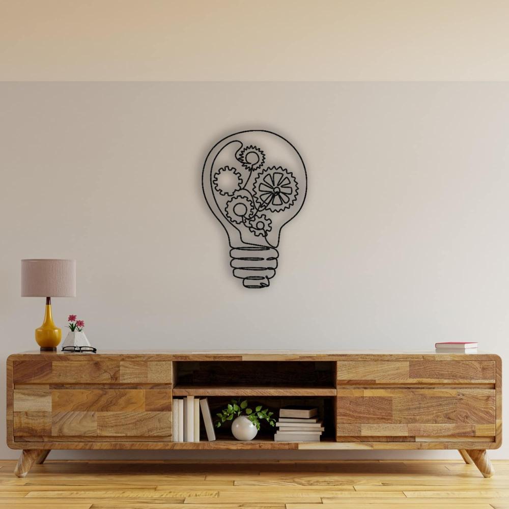 Stylish living space featuring a wooden console table, accessorized with a yellow lamp and books, complemented by a creative light bulb-shaped metal wall art design with gears inside.