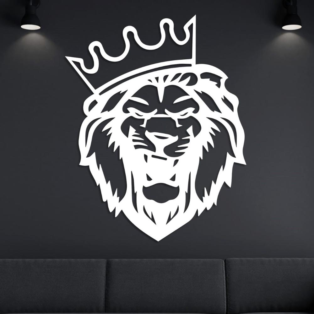 White metal lion head wall art with a crown, elegantly displayed on a dark wall with spotlight accents above a black sofa.