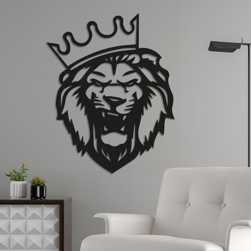 Black metal lion head wall art with a crown, mounted on a light gray wall beside a white armchair and a modern wooden side table decorated with small potted plants.