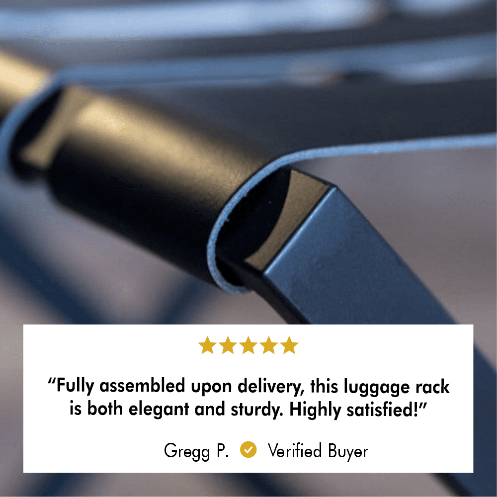 A close-up view of the black metal frame and leather strap of the luggage rack, showcasing its durable craftsmanship and high-quality finish, paired with a five-star review stating, “Fully assembled upon delivery, this luggage rack is both elegant and sturdy.”