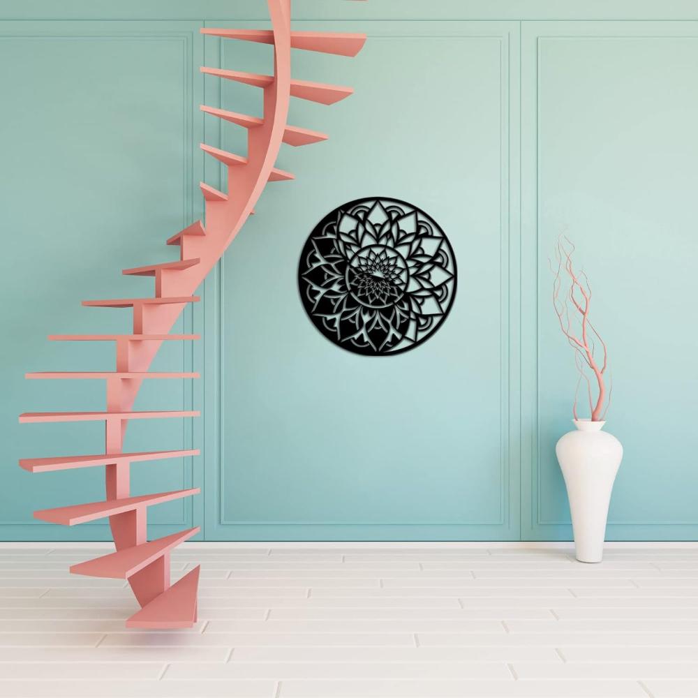 A floral mandala black metal wall art mounted on a teal accent wall, complemented by a striking pink spiral staircase and a white ceramic vase on the floor.