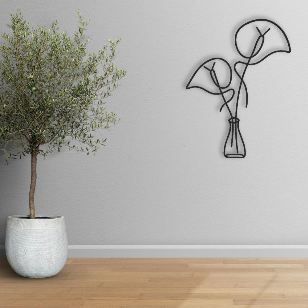 Black minimalist metal wall art depicting abstract leaves in a vase, mounted on a light gray wall. A modern ceramic planter with an olive tree is placed on a wooden floor nearby, creating a serene and natural aesthetic.