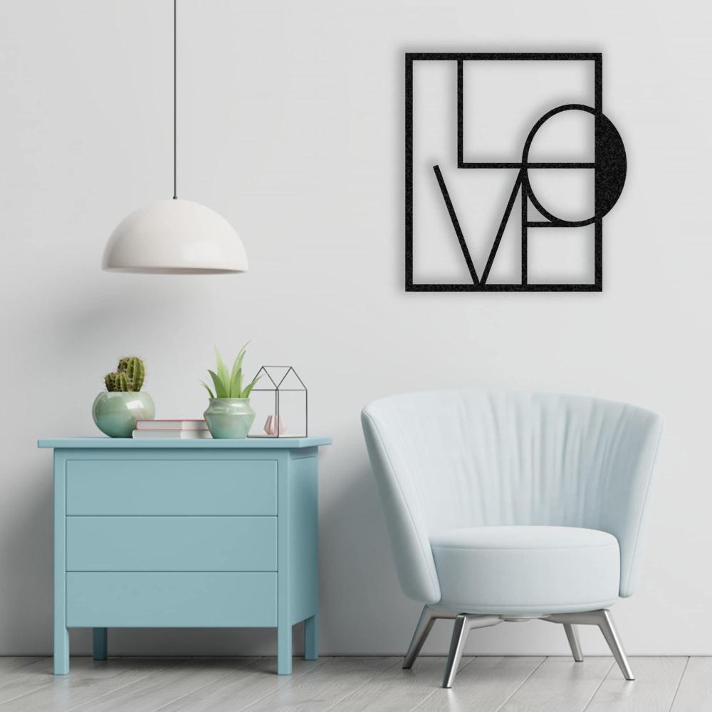 A cozy reading corner with a light grey armchair and wooden floor lamp, complemented by a black metal "LOVE" wall art on a white wall.