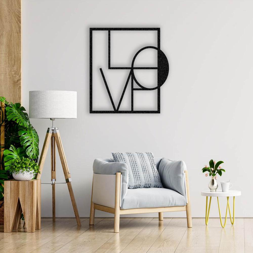 A cozy reading corner with a light grey armchair and wooden floor lamp, complemented by a black metal "LOVE" wall art on a white wall.