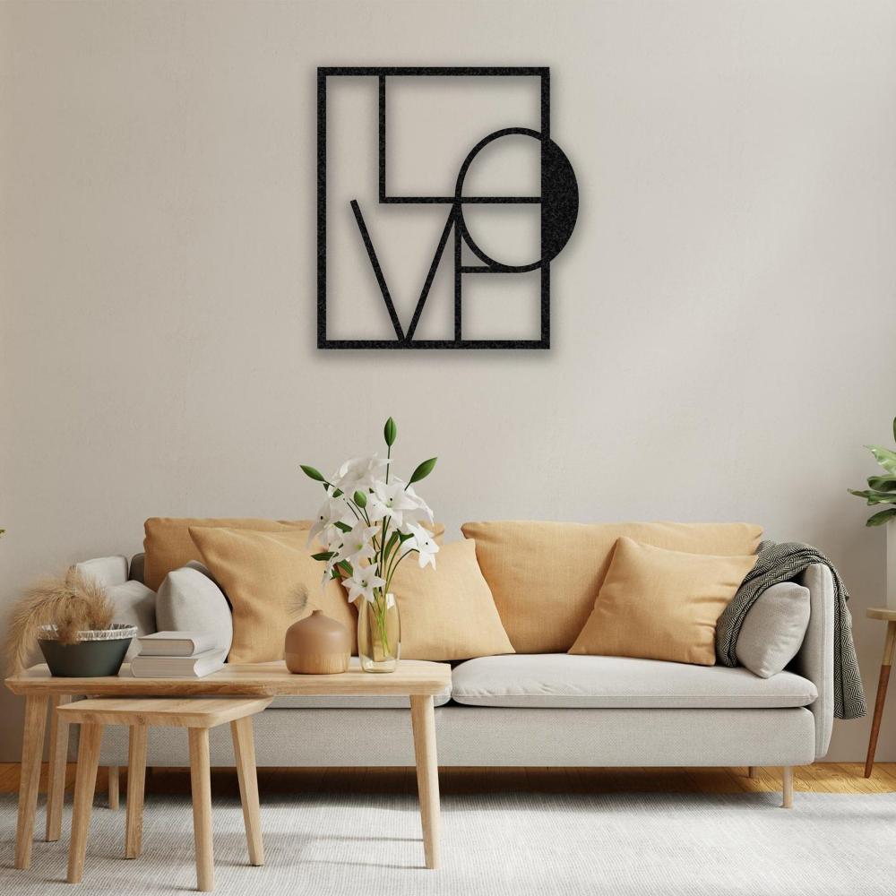 A cozy living room with a light beige sofa accented by mustard-yellow cushions, a wooden coffee table with fresh white lilies, and black metal "LOVE" wall art in a geometric design mounted on the wall.