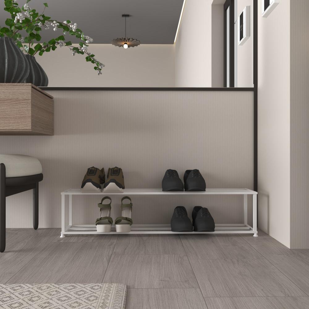 A sleek and minimalist metal shoe rack in a white finish is placed in a modern entryway. The rack has two tiers, each holding neatly organized shoes, with sandals and sneakers on the bottom and formal shoes on the top. The room features neutral tones and contemporary decor, including a potted plant and a modern light fixture, creating a welcoming and stylish space.