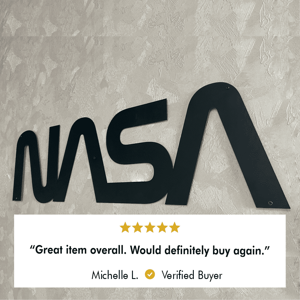 Black NASA metal wall art mounted on a textured beige wall, showcasing sleek, modern design. A verified buyer's review below reads: "Great item overall. Would definitely buy again."