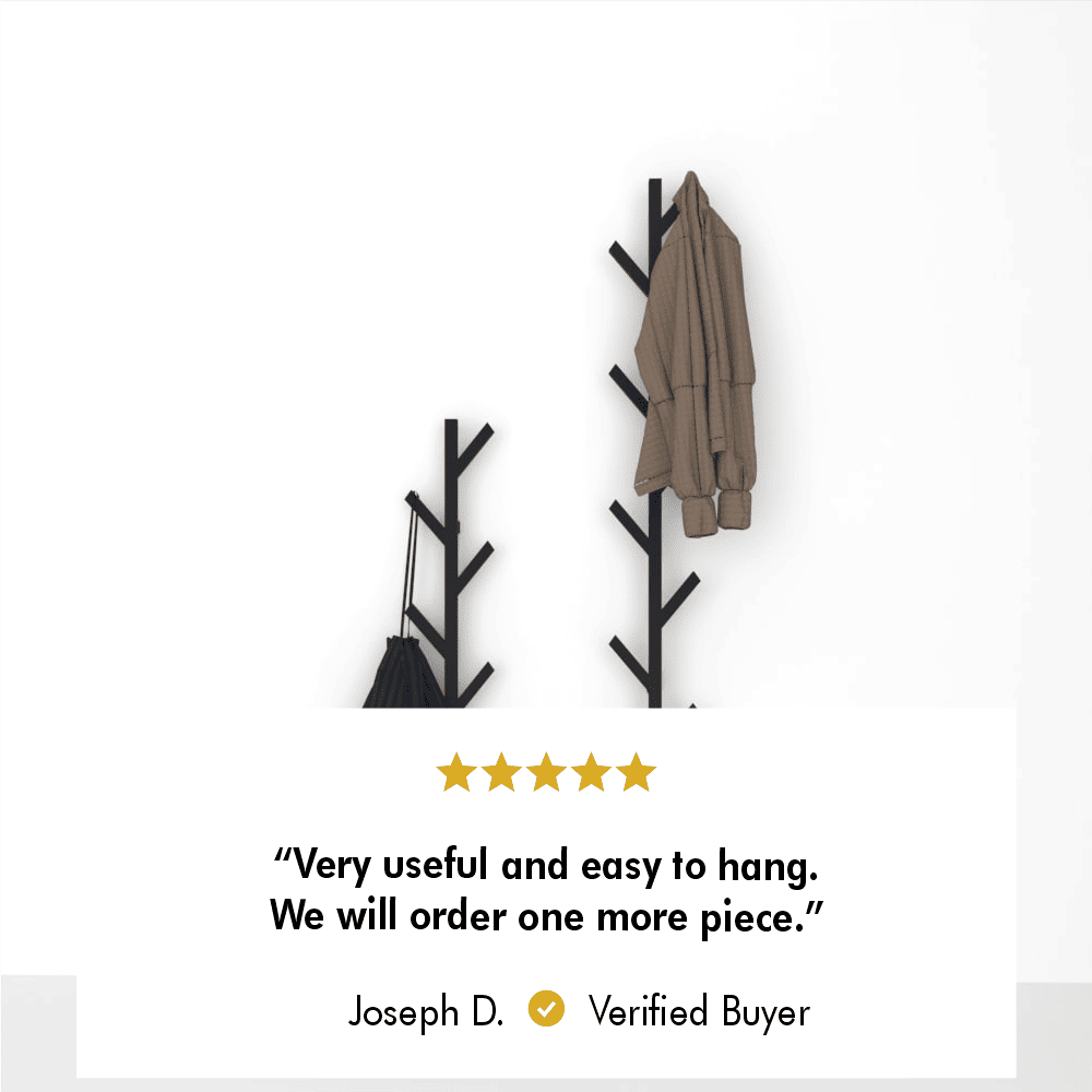 Wall-mounted minimalist coat rack with a tree design, featuring two racks holding a brown coat and a blue bag against a plain white background. A customer review text at the bottom reads: 'Very useful and easy to hang. We will order one more piece.' - Joseph D., Verified Buyer.